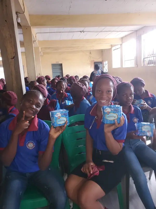 Students holding the free sanitary pads they received